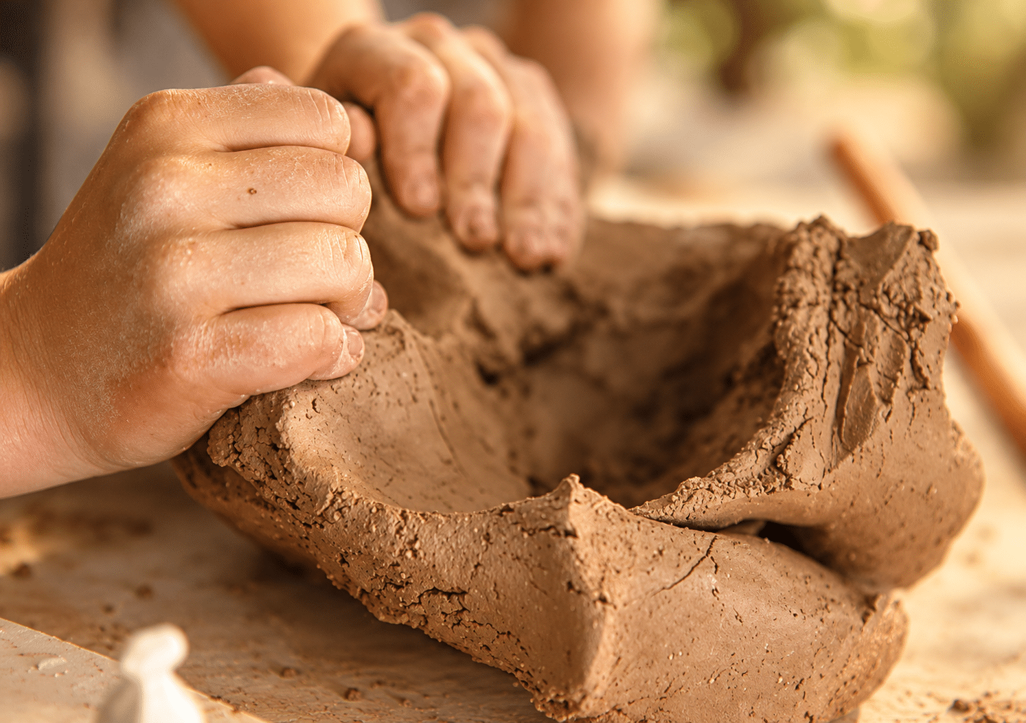 Hands shaping clay at The Potters House pottery studio in Crossfield